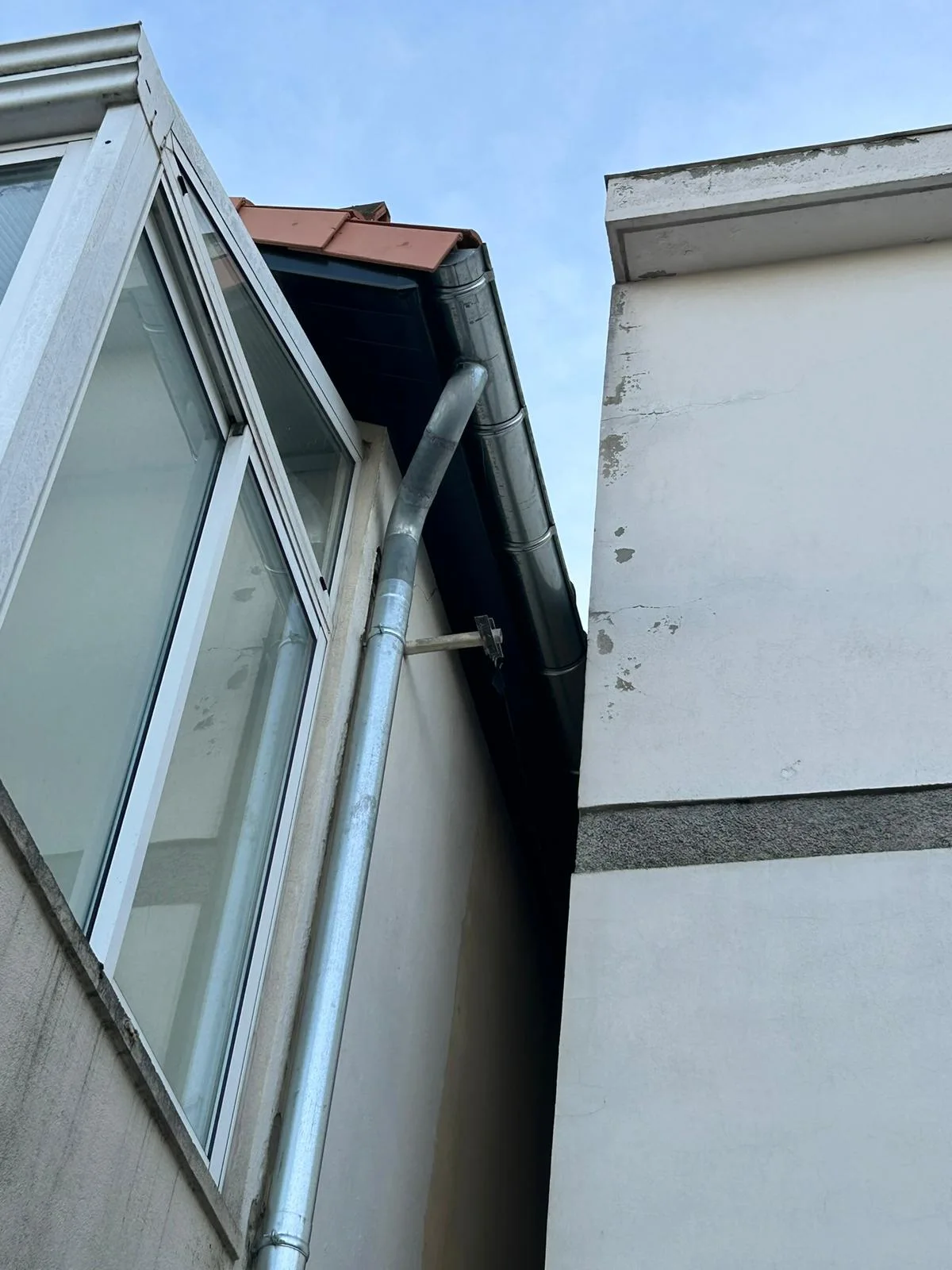 Détail d’un raccord en zinc contre une maçonnerie.